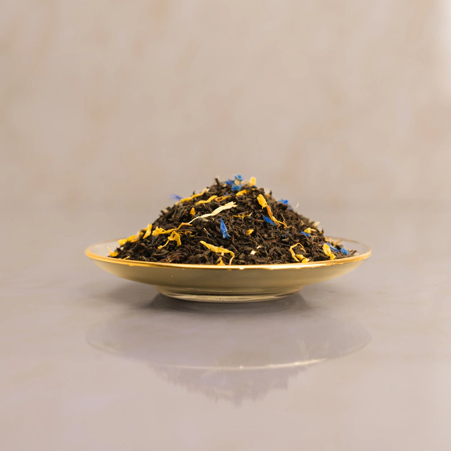 Tea leaves on a gold plate with a beige background