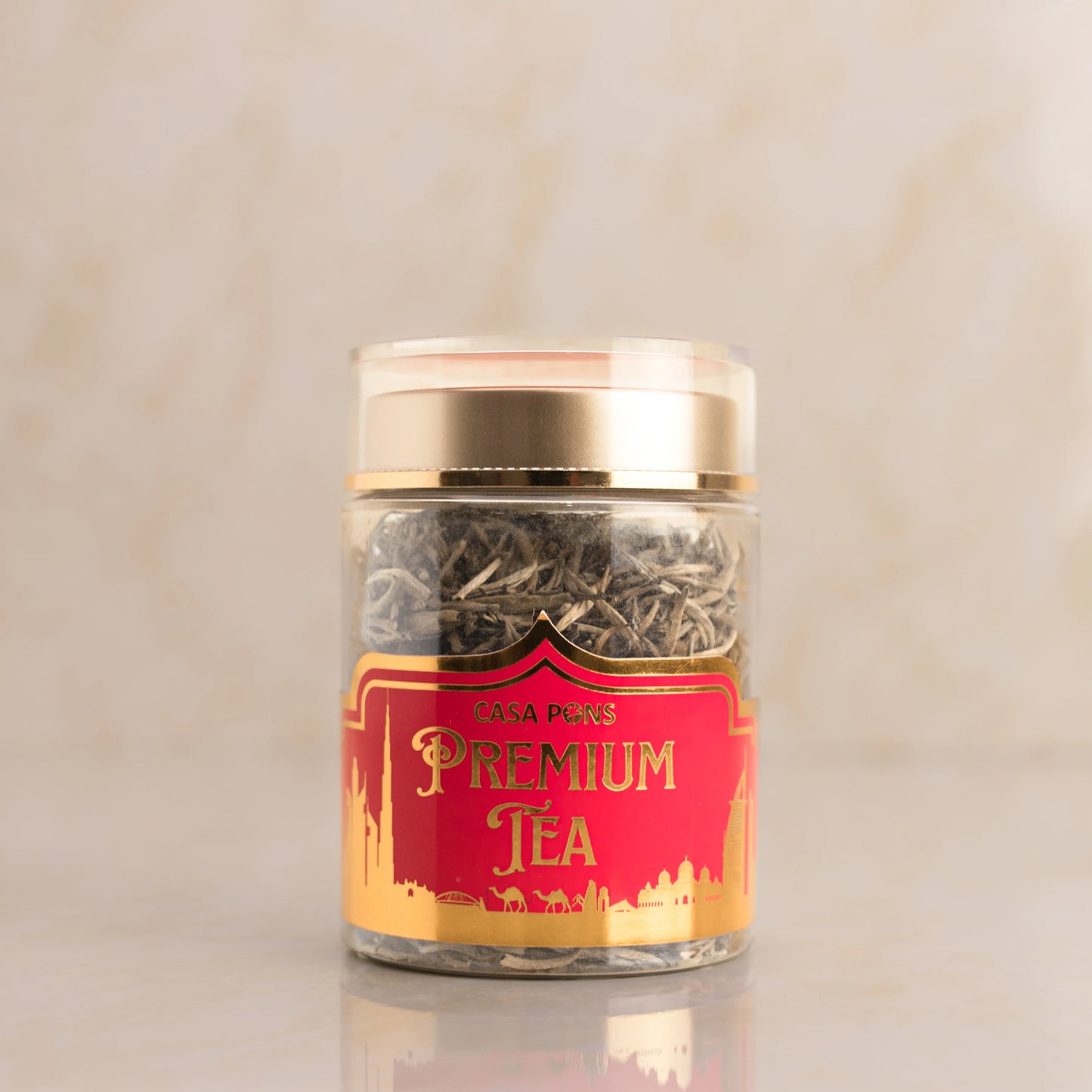 Jar of premium tea with a red label on a beige background