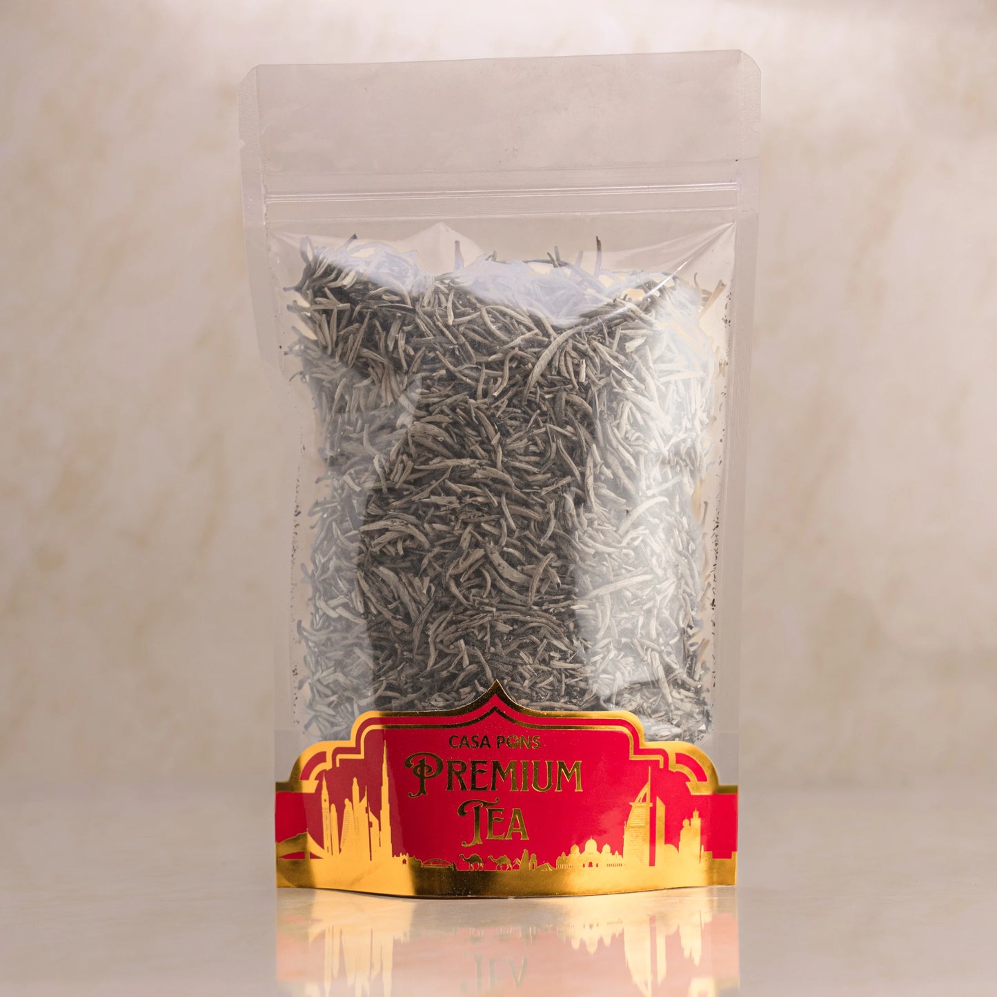 Clear plastic bag with tea leaves and a red label on a beige background