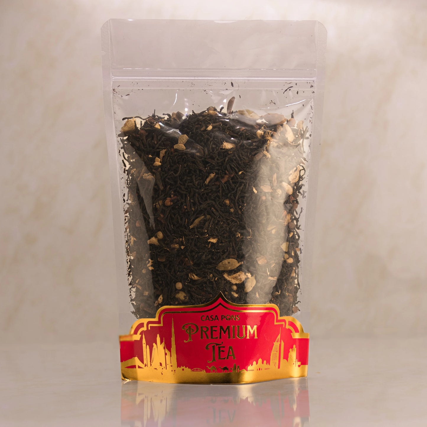 Clear plastic bag with black tea leaves and a red label on a light gray background
