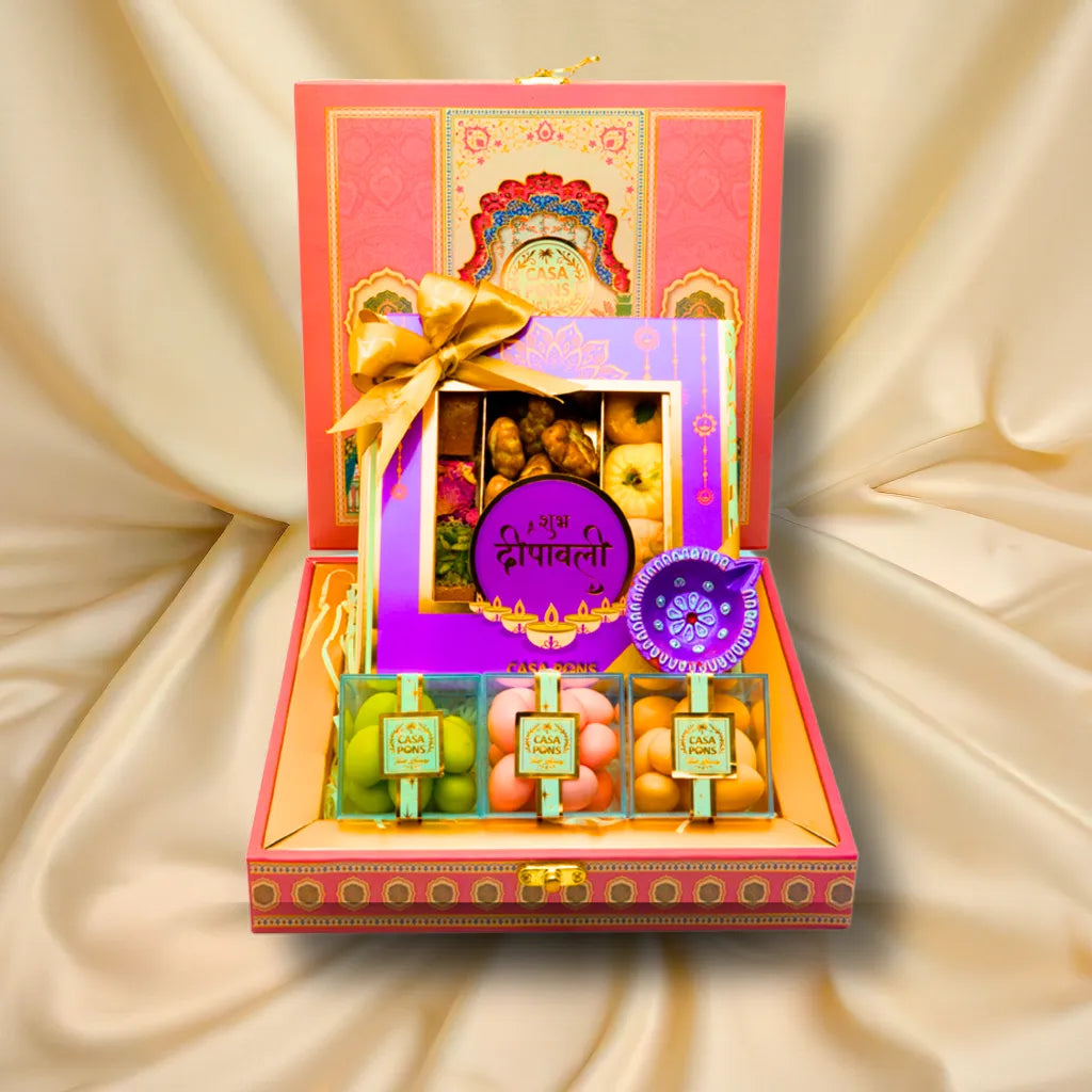 Small Pink Peacock Basket Diwali gift with pecans, traditional sweets, malban, marzipan, almond dragées, and diya in handcrafted Indian packaging.