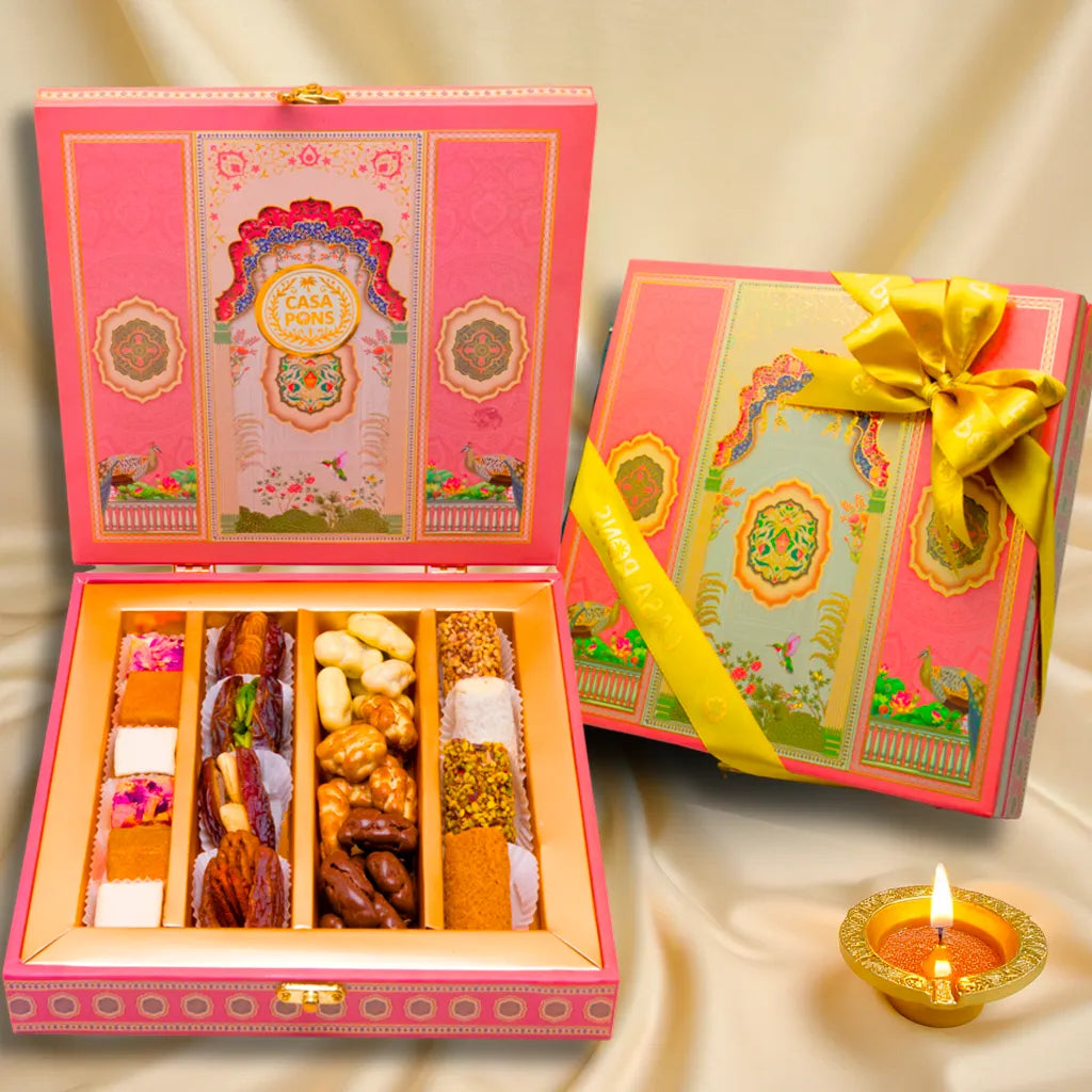 Decorative gift box with a variety of snacks and a lit candle on a soft background
