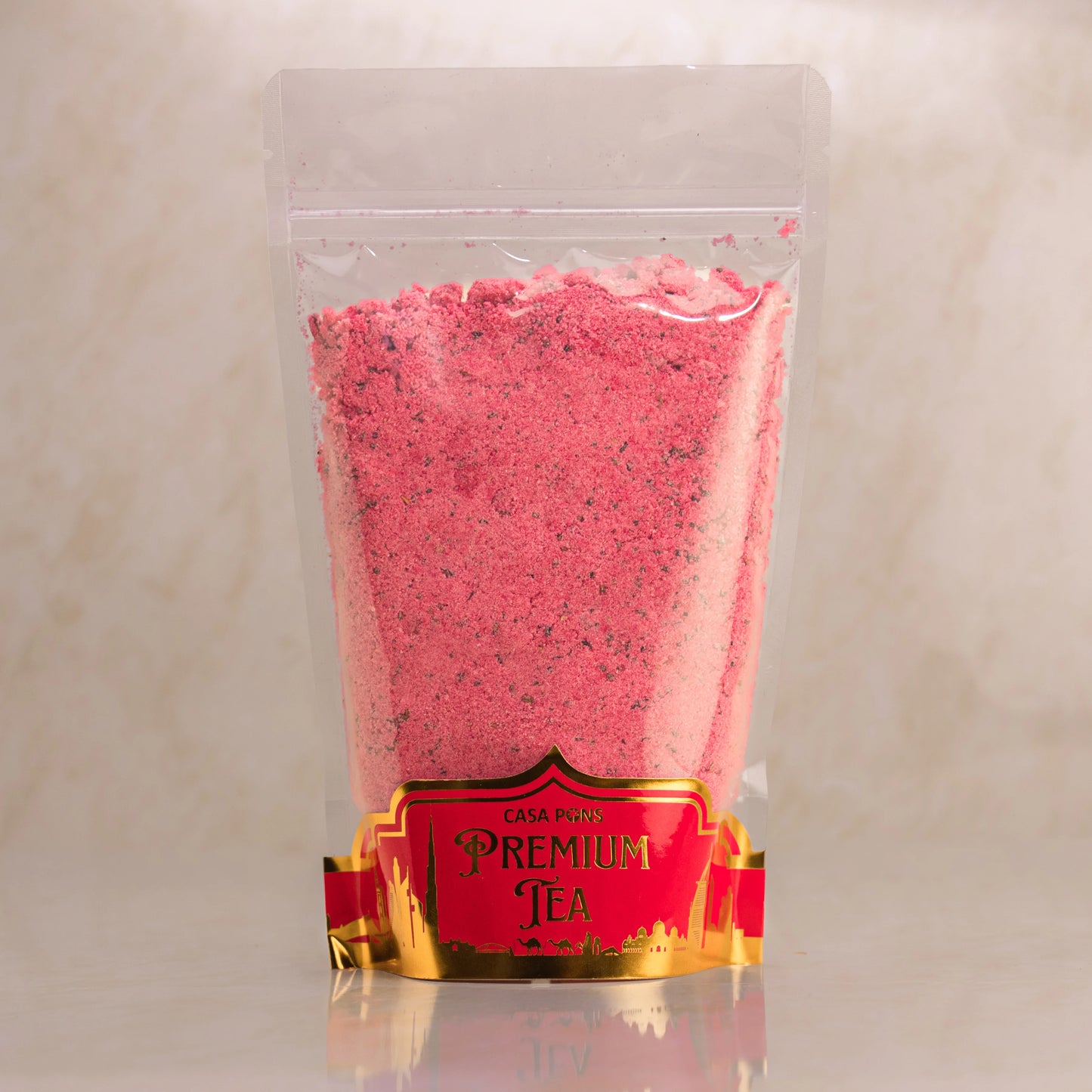 Pink tea powder in a clear plastic bag with a red label on a beige background