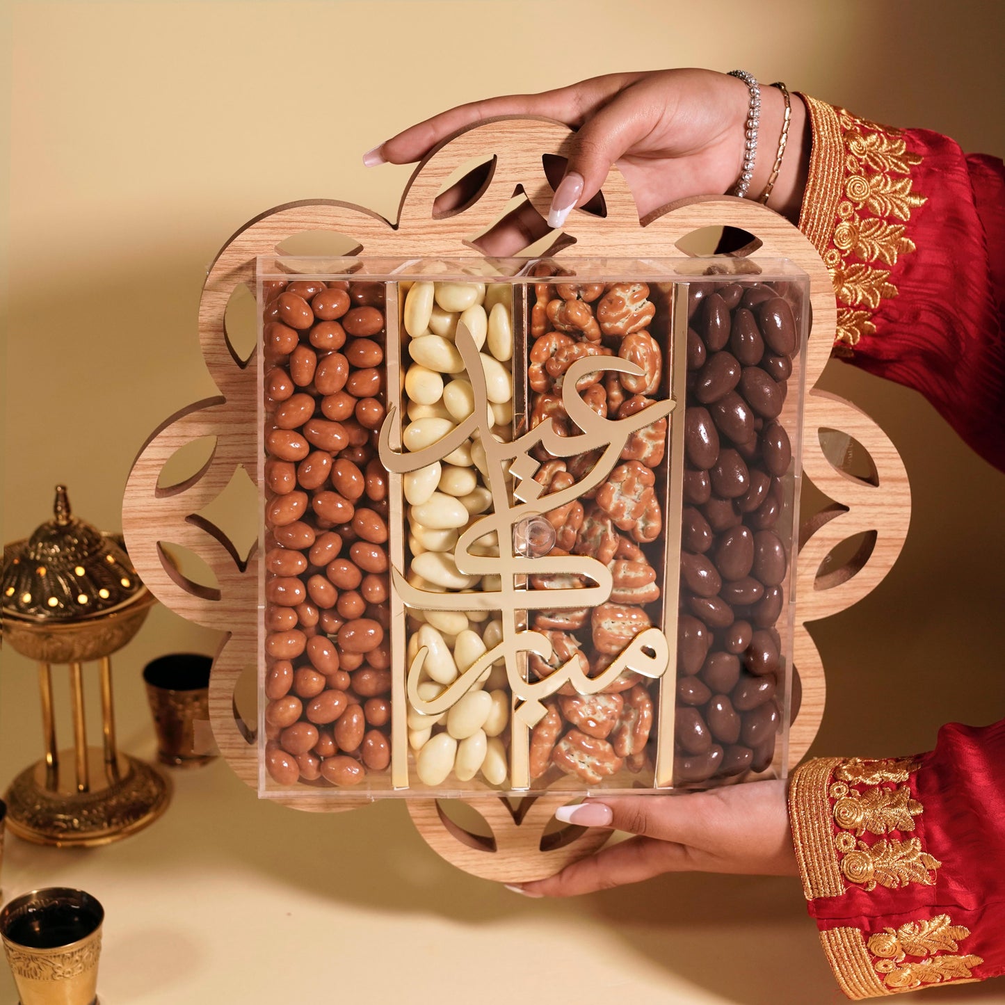 Hand holding a wooden box of assorted nuts with a decorative background
