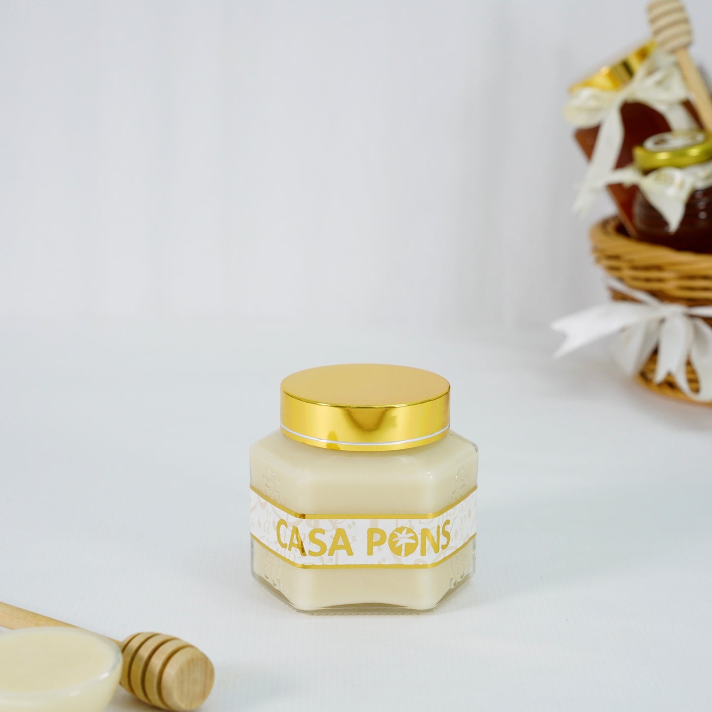 Jar of Casa Pons honey with a gold lid on a white background