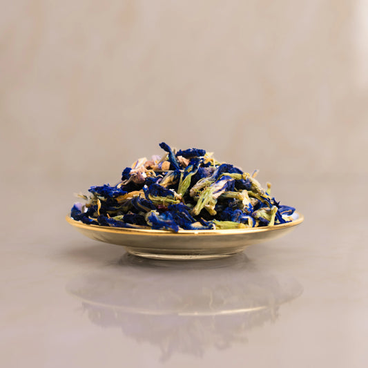 Dried blue and white flowers on a beige plate against a beige background