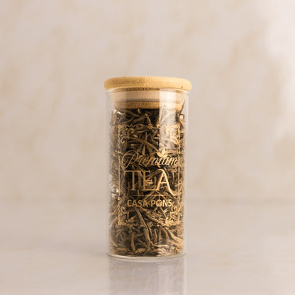 Jar of tea leaves with a wooden lid on a beige background