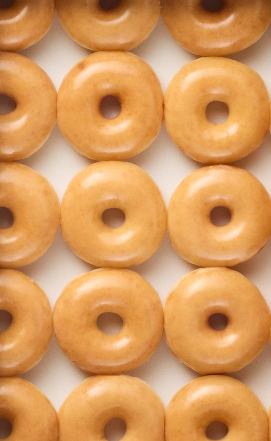 Pattern of glazed donuts on a white background
