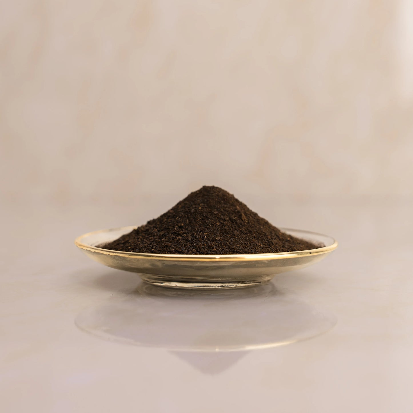 Lemon dark brown powder on a small plate with a beige background