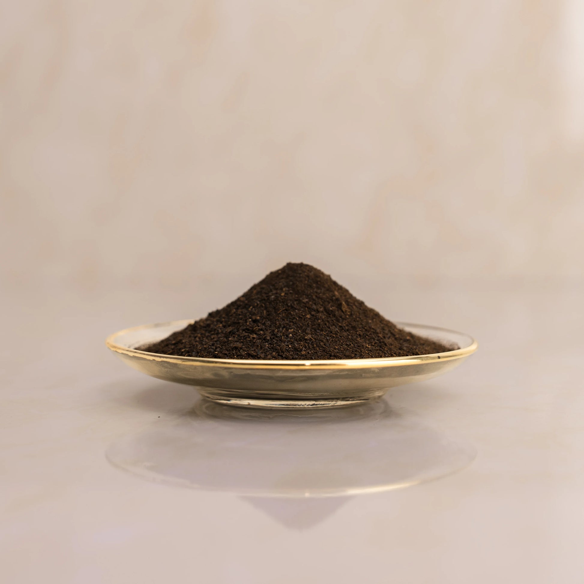 Lemon dark brown powder on a small plate with a beige background