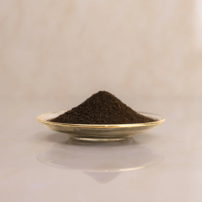 Lemon dark brown powder on a small plate with a beige background