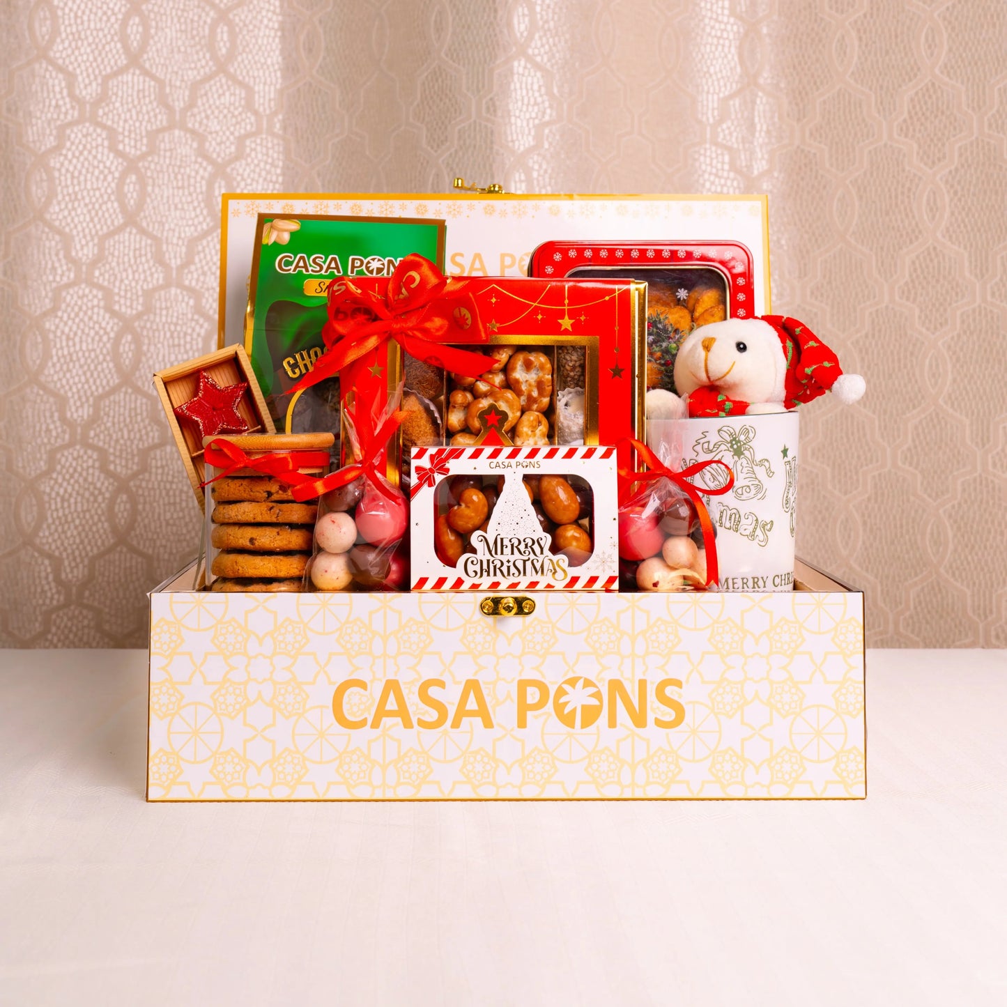 Gift basket with a teddy bear and various items in a decorative box, featuring the brand 'Casa Pons'.