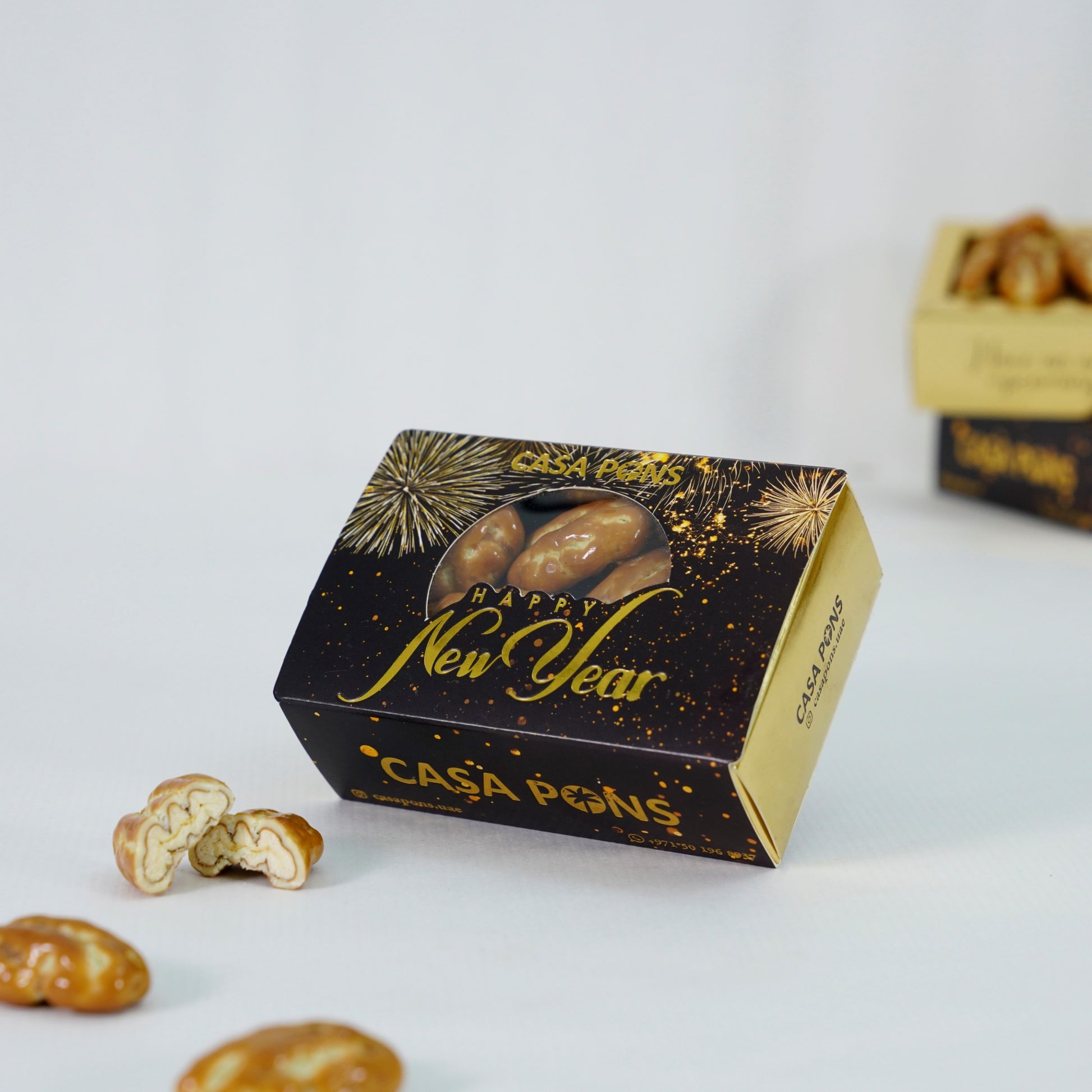 Casa Pons New Year giveaway box filled with caramel pecans on a white background.