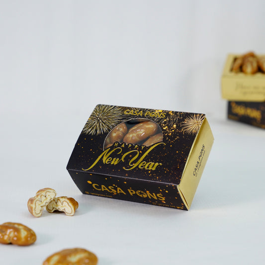 Casa Pons New Year giveaway box filled with caramel pecans on a white background.
