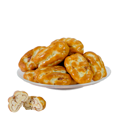 A plate of pecan caramel treats, with a focus on one treat showing the pecan nuts on the side.