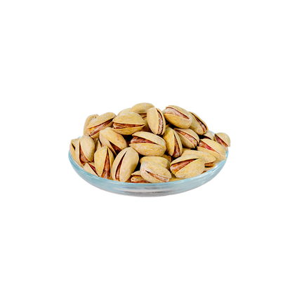 A bowl of pistachio kharouf, which are salted pistachios, against a white background.