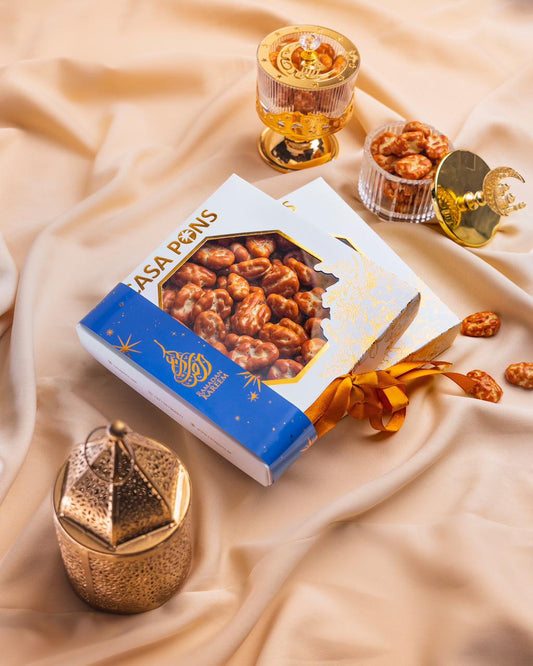 Box of Asa P Gins with gold containers and decorative items on a beige fabric background