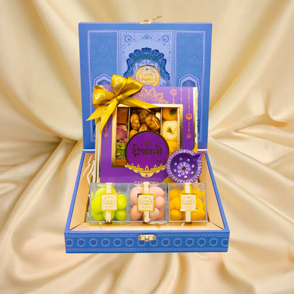 Small Blue Peacock Basket Diwali gift with pecans, Indian sweets, malban, marzipan, almond dragées, and diya in handcrafted basket.