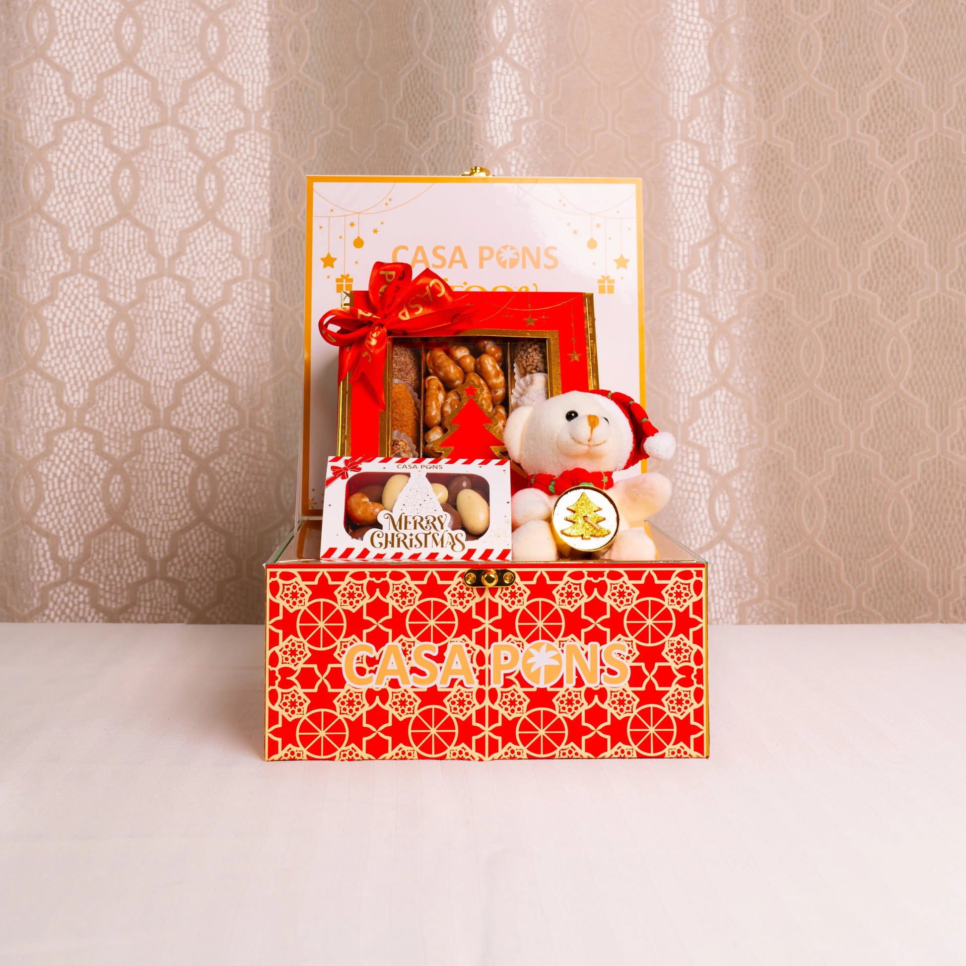 Decorative gift box with a teddy bear and cookies on a textured beige background