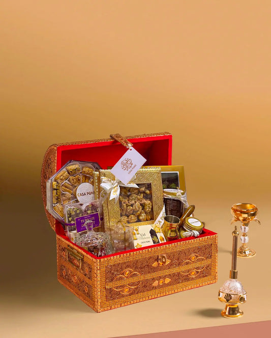 Small Tresor gold treasure-style gift chest with Arabic sweets, maamoul, baklava, nuts, chocolates, royal mix nuts, bukhoor burner, and Turkish coffee kanaka.