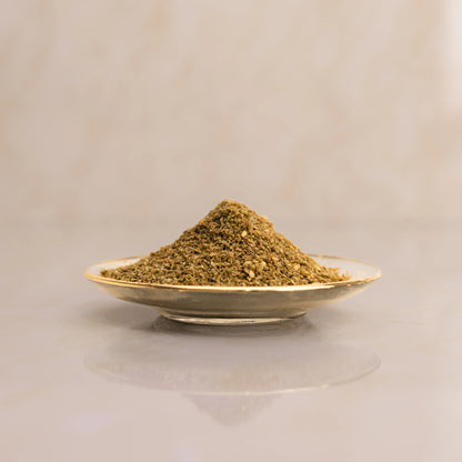 Herbal powder on a small plate with a beige background