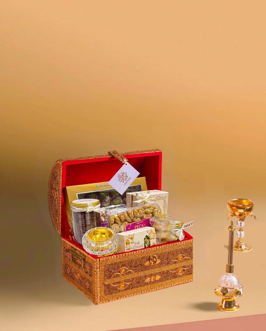 Decorative gift box with snacks and a small lamp on a beige background