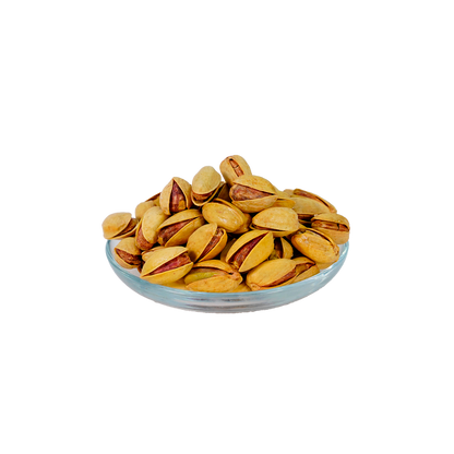 A glass bowl filled with pistachio nuts against a white background.