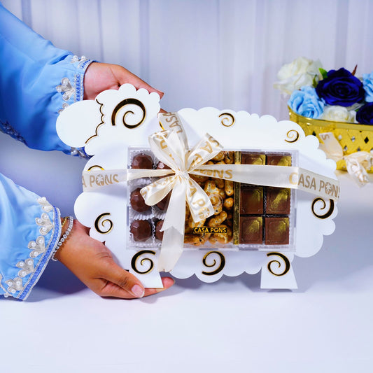 Hand holding a box of chocolates with 'Casa Pons' branding against a white background