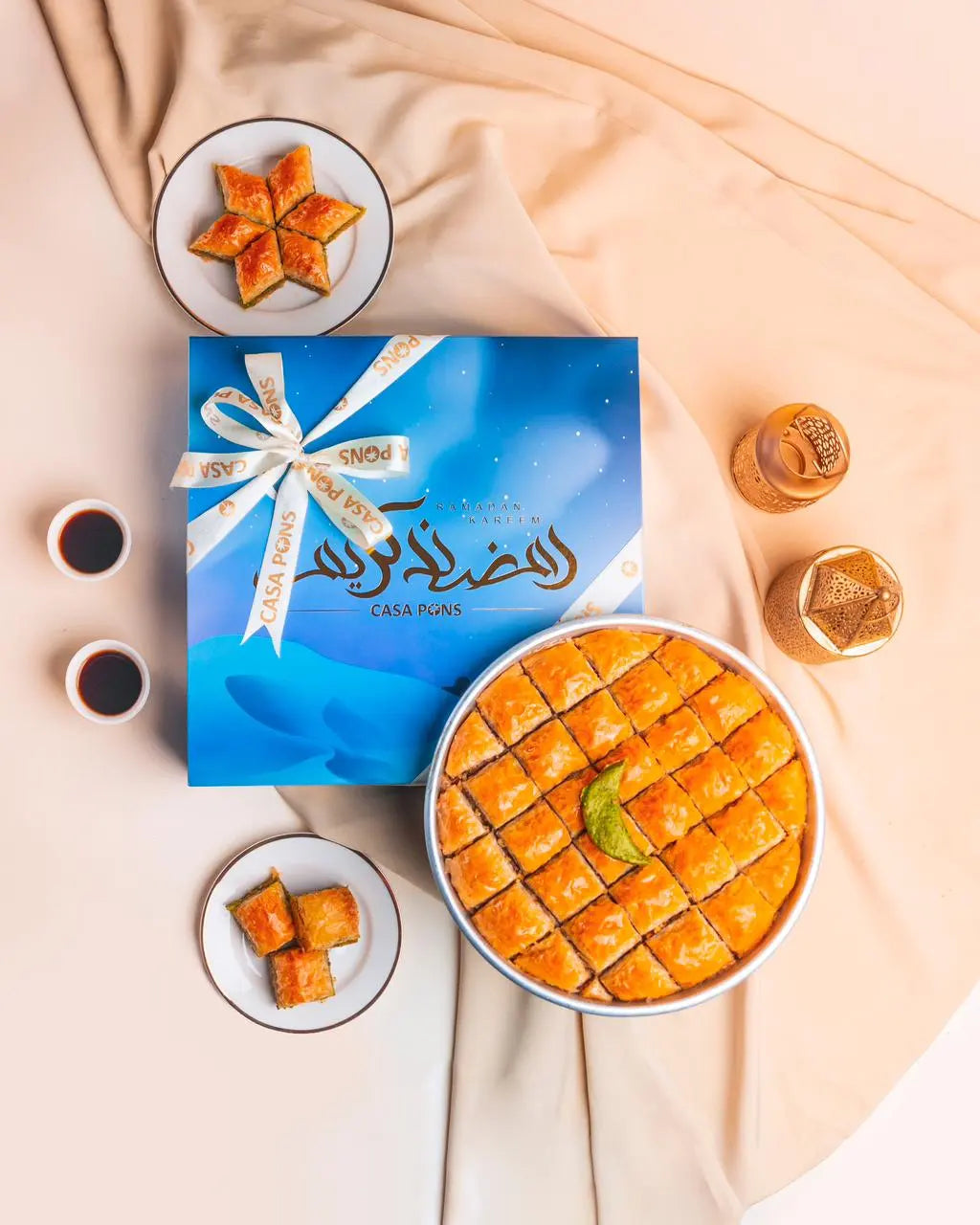 Baklava with a blue gift box on a beige fabric background