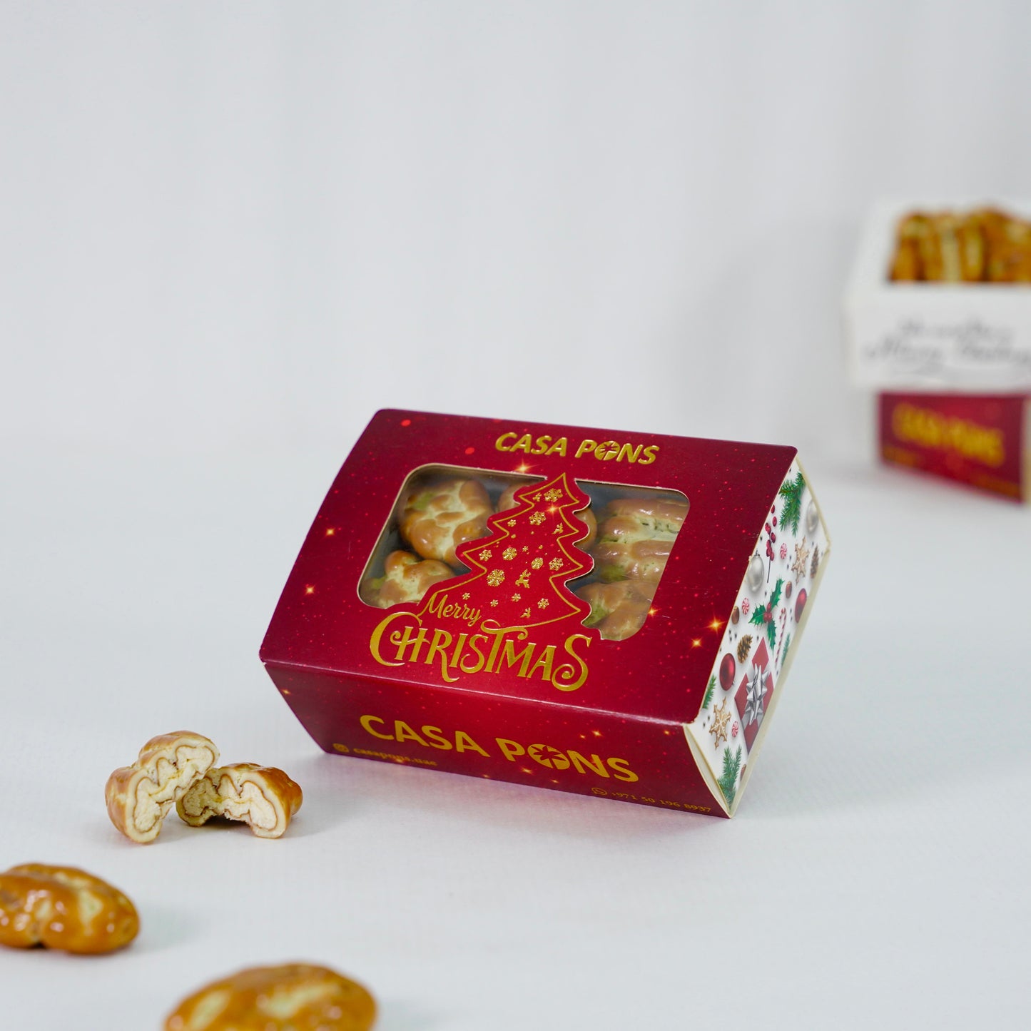 Red Christmas-themed box of Casa Pons cookies with a clear window showing the cookies inside.
