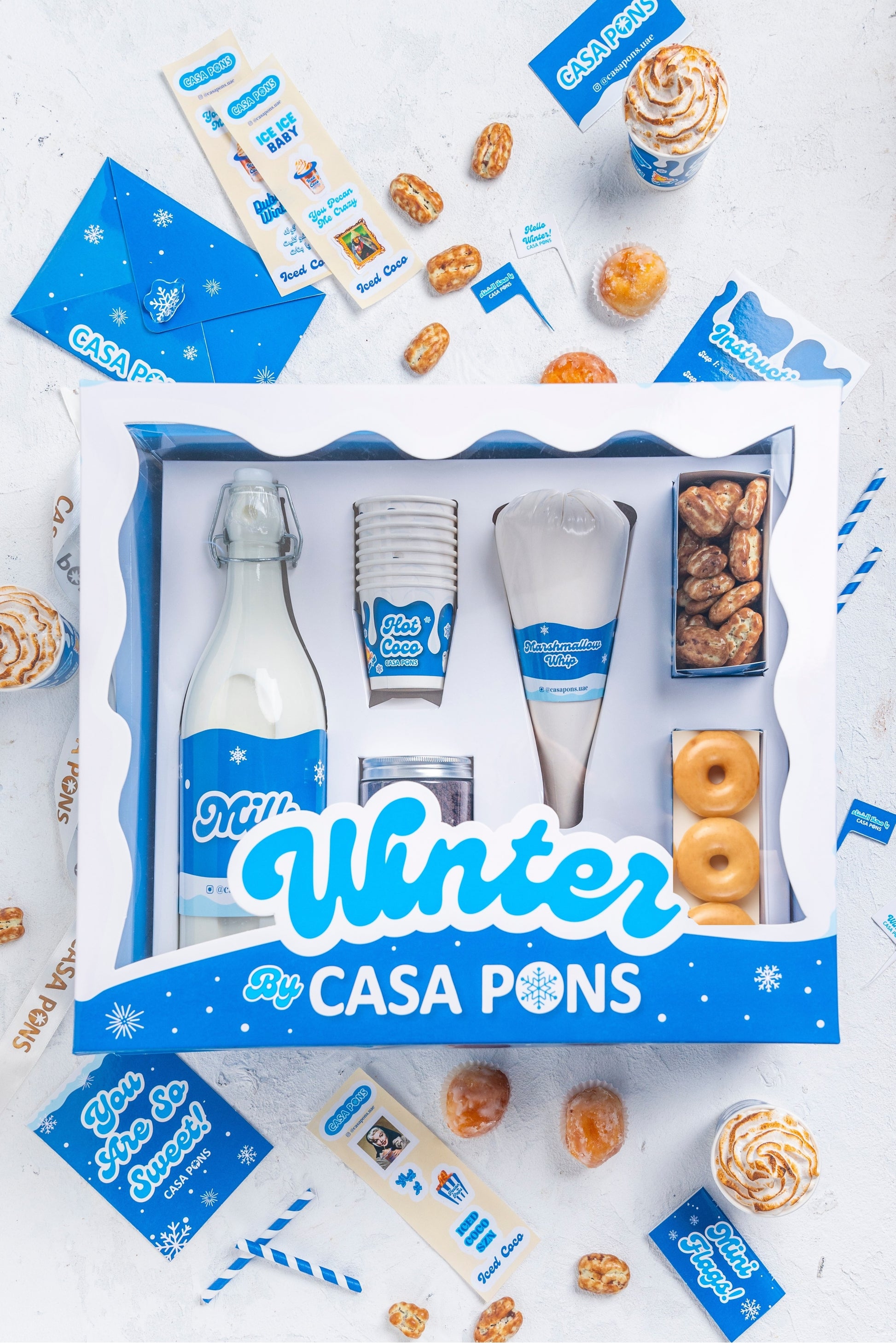 Casa Pons winter-themed product set with bottles, cups, and snacks on a white background